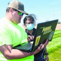 Aaron McCambridge, left, a student at Purdue Polytechnic Anderson, works with Rashmi Deodeshmukh, assistant professor of practice, near a farm field lab on which the institute is partnering with NineStar Connect in Hancock County. (Submitted photo)