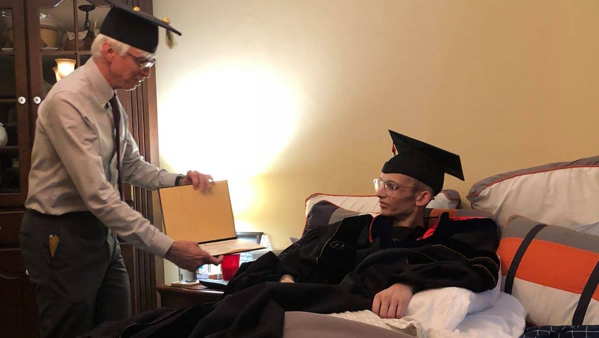 Gary Bertoline, dean of Purdue Polytechnic, awards an Associate of Science Degree to Tyler Trent.