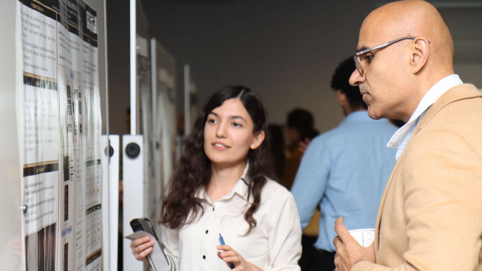 Guest speaker Navdeep Jaitly (right) speaks with a student about research during the Applied AI Day poster session. (Purdue University photo/John O'Malley)
