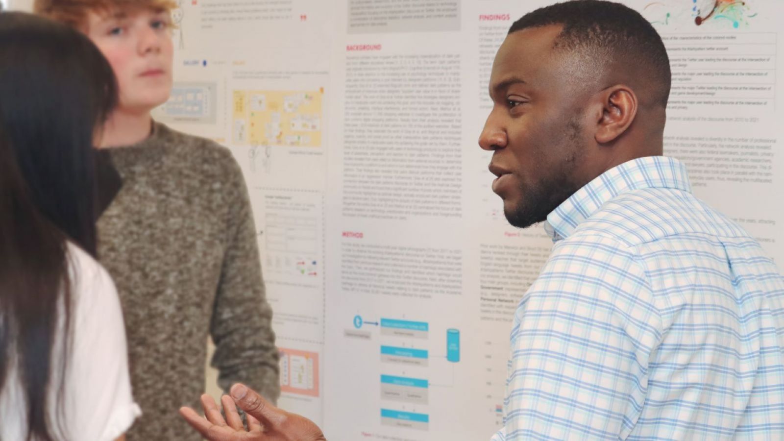 Ike Obi (right), PhD student in the Department of Computer and Information Technology, discusses research projects during a poster session at Stewart Center. (Purdue University photo/John O'Malley)