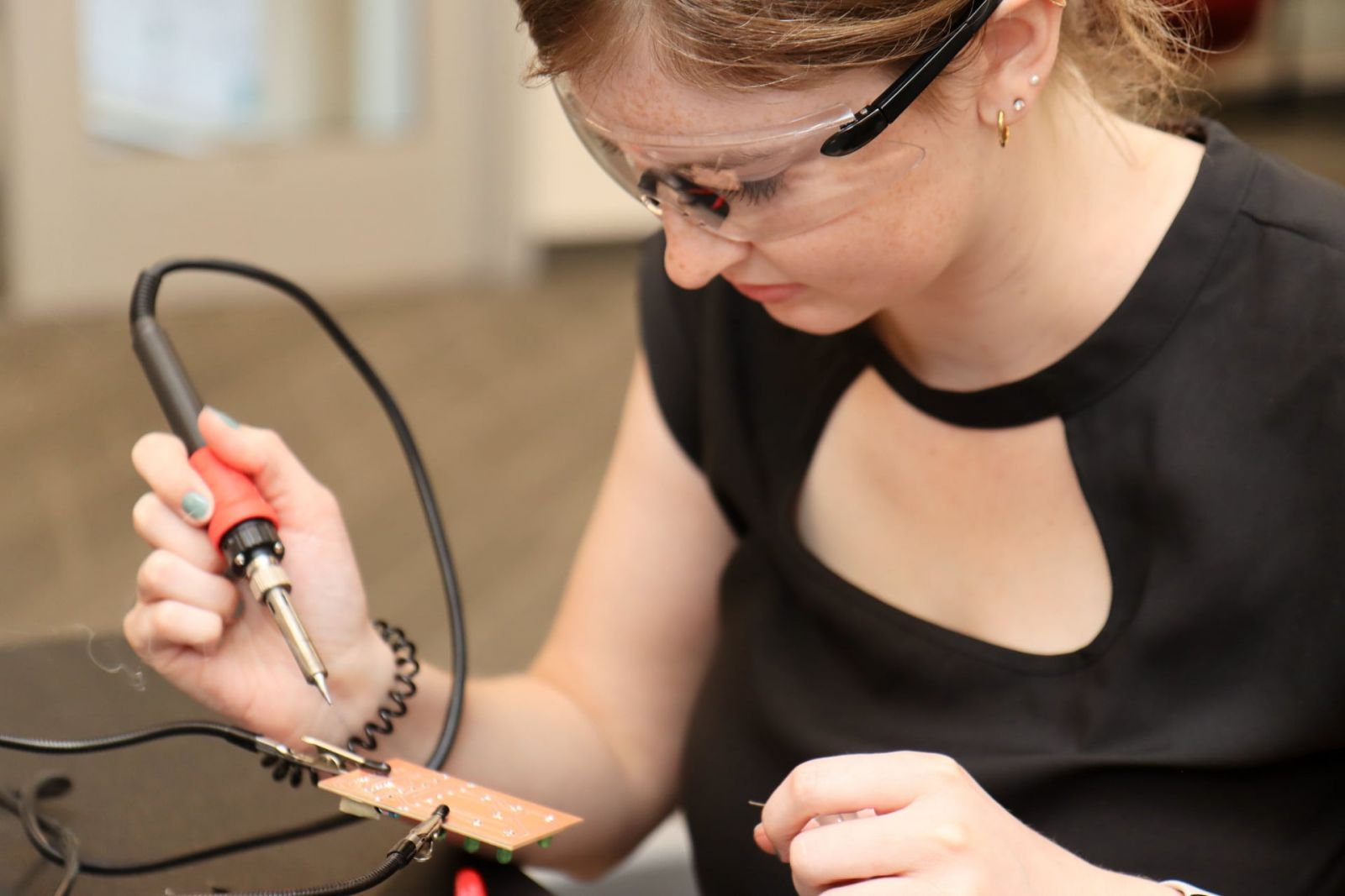 Amiah Clevenger, a junior in Purdue Polytechnic’s Engineering Technology Teacher Education major, solders a circuit board during the SCALE K-12 workshop. (Purdue University photo/John O’Malley)