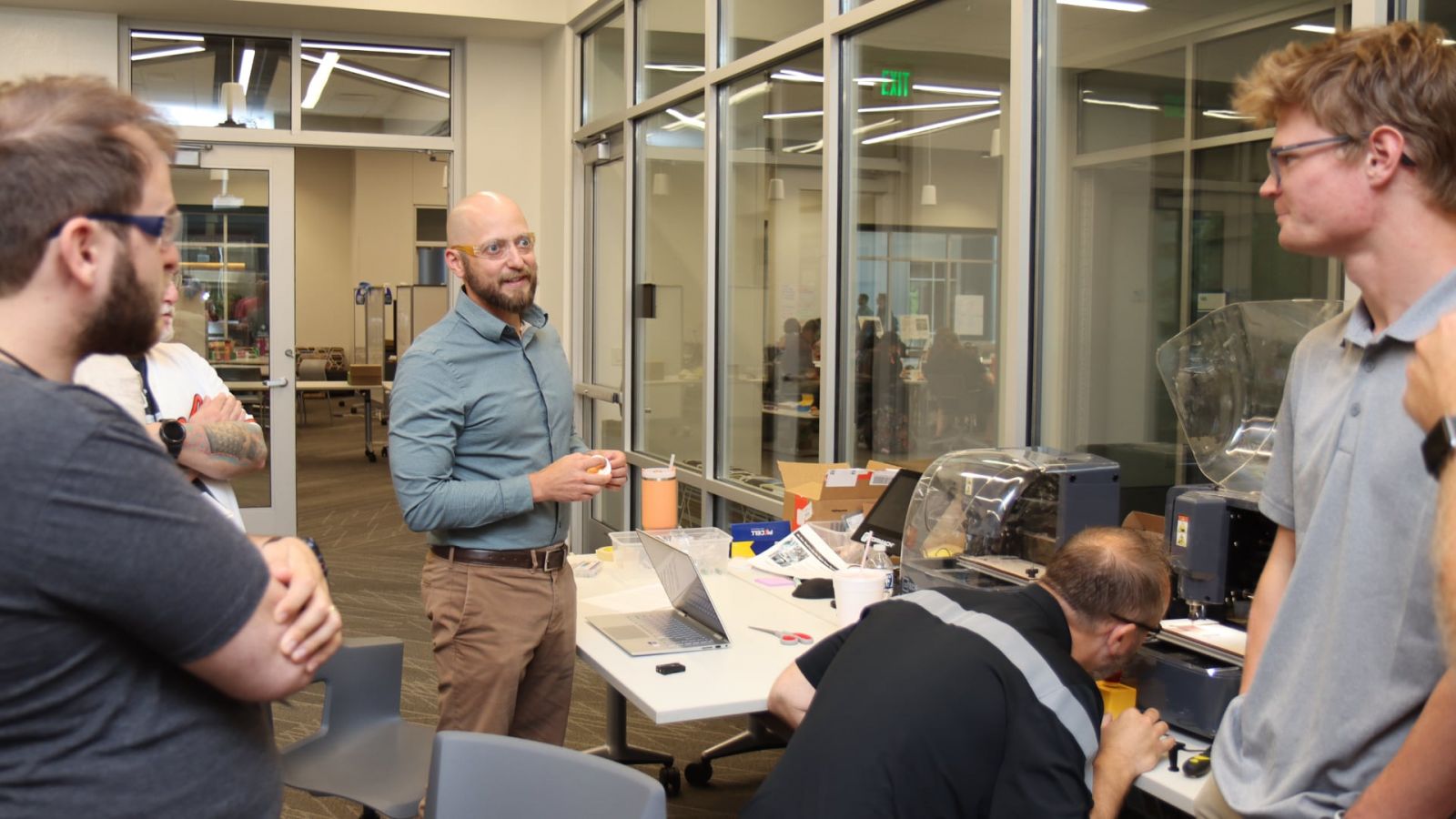 SCALE K-12 workshop participants work with a computer numerical controlled (CNC) machine to manufacture small circuit boards under the guidance of Purdue Polytechnic’s Greg Strimel (center), associate professor of technology leadership and innovation. (Purdue University photo/John O’Malley)